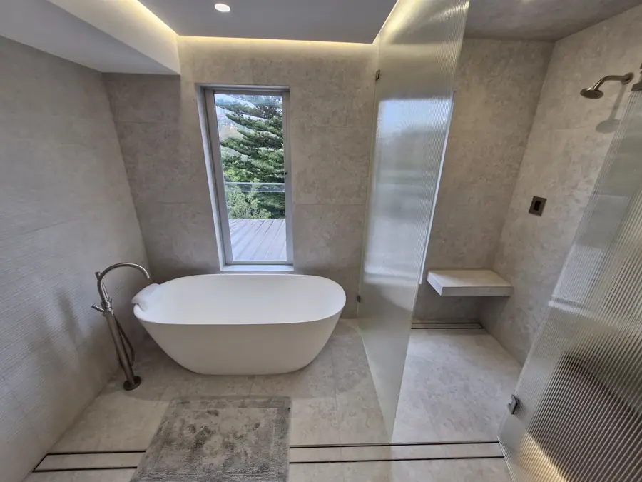 Frameless glass shower opening onto a timber deck