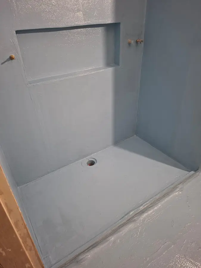 Waterproofed shower base with floor waste set to fall